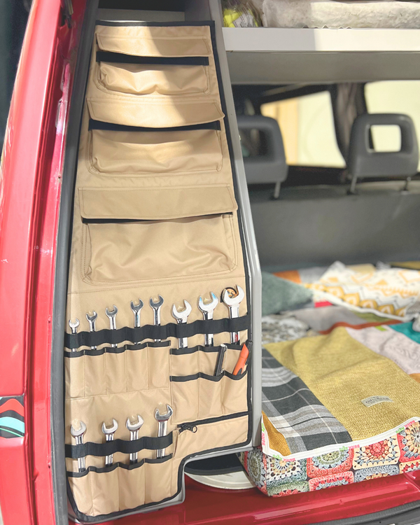 Tool organizer hanging on a car door with various tools inside