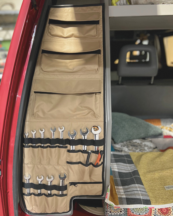 Roll-up tool organizer with tools inside, attached to a car door.